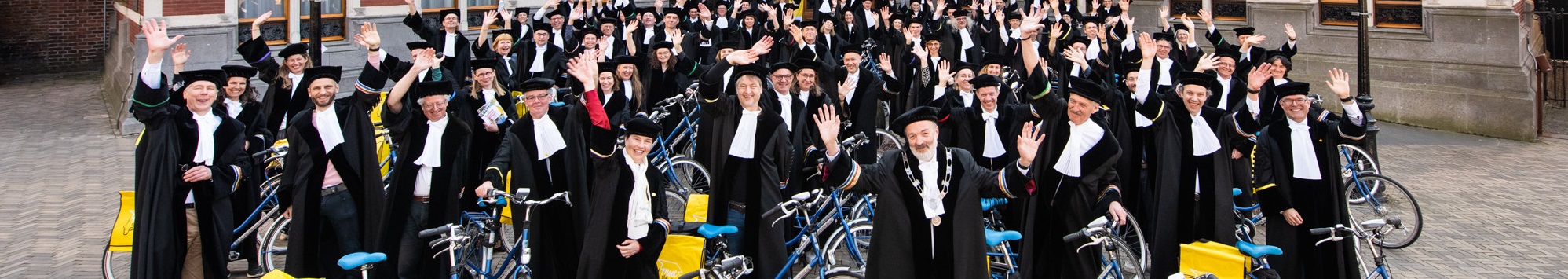 Hoogleraren poseren met hun fiets voor het Academiegebouw in Utrecht
