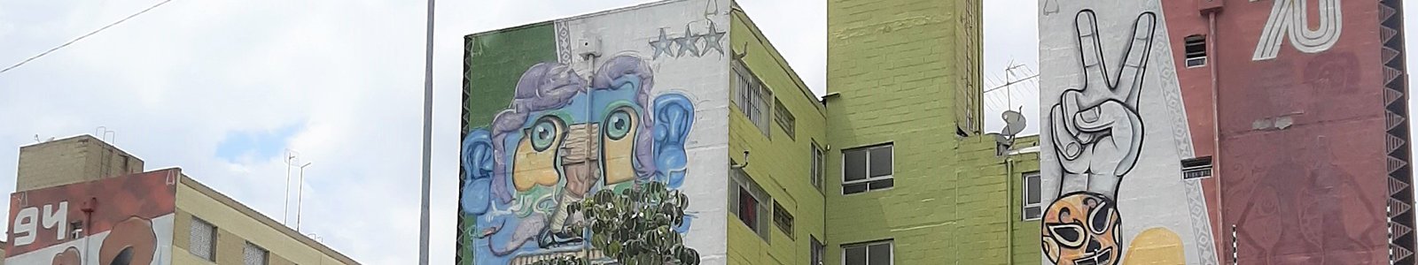 Three murals in a row, each painted high on the side of buildings; key images include a colourful abstract face and a hand making a peace sign.