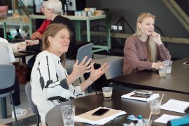 Researchers sitting at a table: two white women engaged in conversation