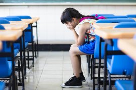 Meisje huilt in handen in klaslokaal