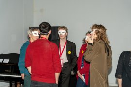 A group of people talking while wearing white eye masks