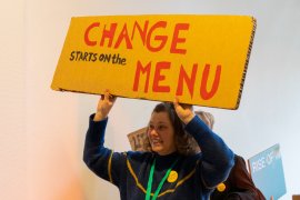 women holding protest sign 'CHANGE starts on the MENU'