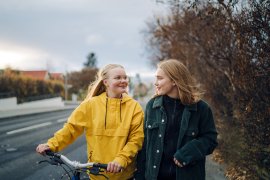 Twee tiener vriendinnen lopen met de fiets.