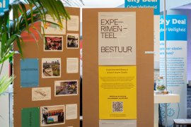 Cardboard display with different coloured posters about publication 'Experimental Governance' at 'Dag van de Stad 2019'