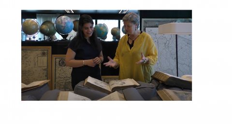 a student and teacher browsing an old science book
