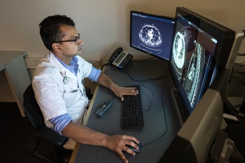 Radioloog Firdaus Mohamed Hoesein bekijkt longfoto's van een COVID-patiënt