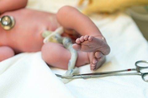 Pasgeboren baby met navelstreng