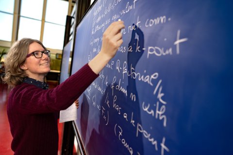 Marta writing with chalk on a blackboard