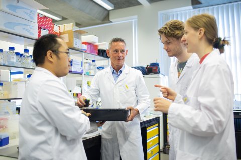 Corné Pieterse in een onderzoeksruimte met drie collega's