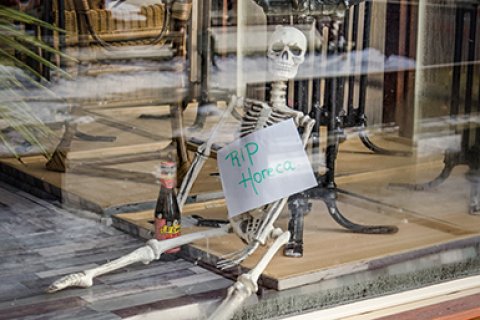 Skelet in etalage met bord RIP horeca © iStockphoto.com/franswillemblok