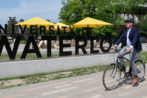 Brian Doucet fietst op de campus van Universiteit Waterloo, Canada