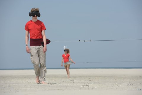 Twee mensen op het strand met een VR-headset op
