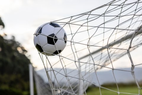 Een voetbal in het net van de goal
