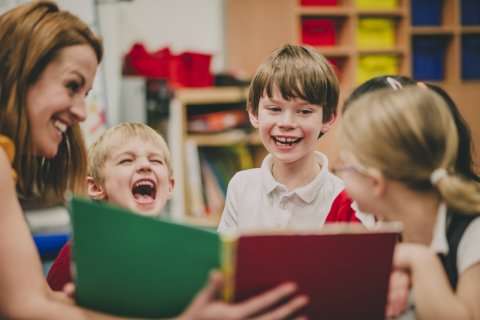 Vrouw en lachende kinderen in een klaslokaal