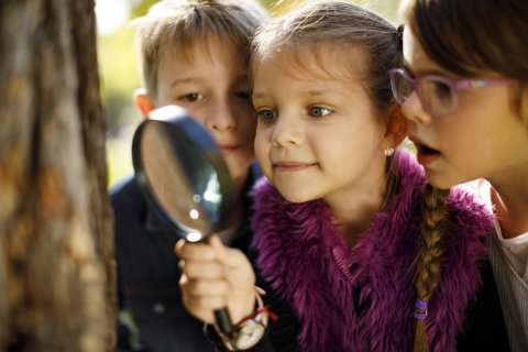 Kinderen kijken door een vergrootglas