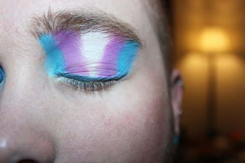 Make-up op ooglid in de kleuren van de transgender vlag