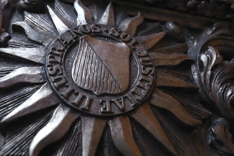 Historisch logo Universiteit Utrecht op houten bank