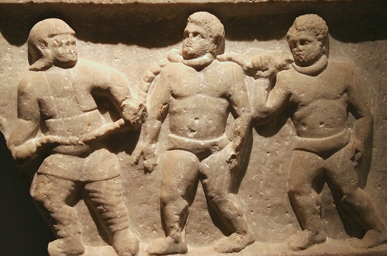 Een Romeins soldaat leidt krijgsgevangenen weg in kettingen (reliëf uit Smyrna). Bron: Wikimedia/Jun - Flickr: Roman collared slaves, CC BY-SA 2.0, 
