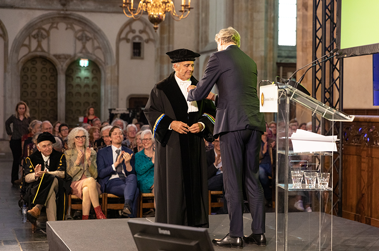 Frits van Oostrom krijgt zijn koninklijke onderscheiding opgespeld van minister Robbert Dijkgraaf. Foto: © Annemoon van Hemel