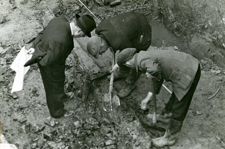 Archeoloog Albert van Giffen kijkt toe terwijl twee werklieden werken aan de opgraving van het Romeinse castellum in Valkenburg (ZH) in 1941-1943. Foto: Rijksmuseum van Oudheden (CC-BY 3.0)
