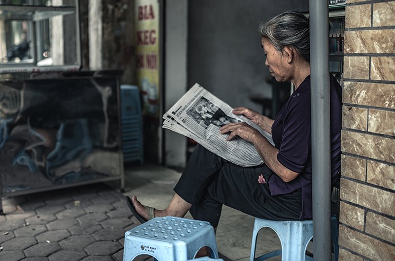 Een Vietnamese vrouw leest de krant © iStockphoto.com/sankai