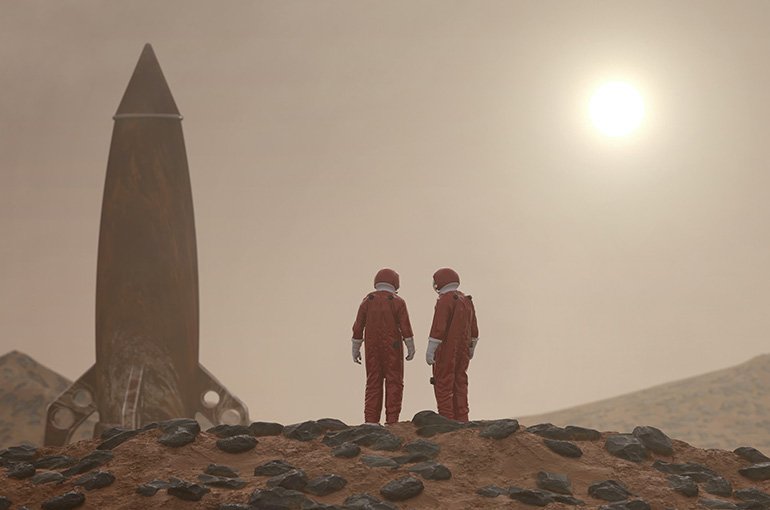 Een raket en twee astronauten op een mistige planeet. Foto: Mike Kiev, via Unsplash