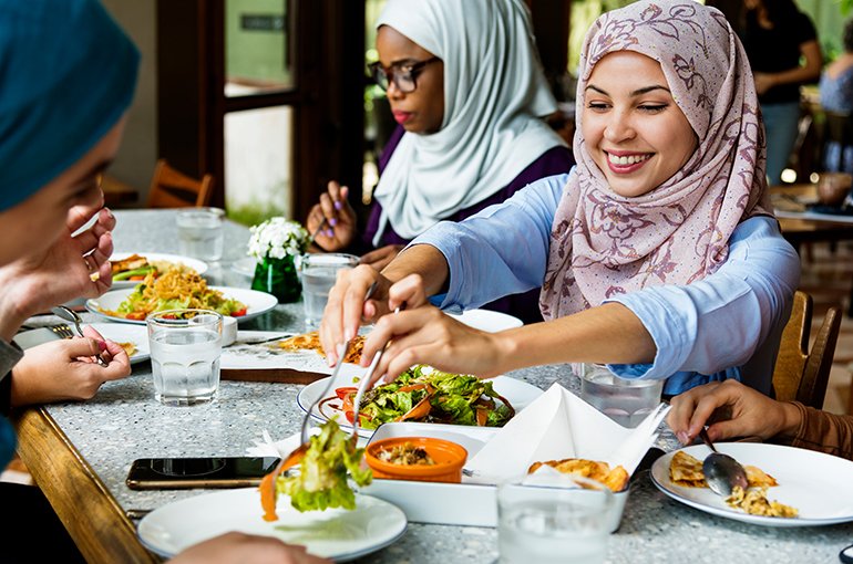 Restaurant met een groep moslima die uit eten zijn © iStockphoto.com/Rawpixel