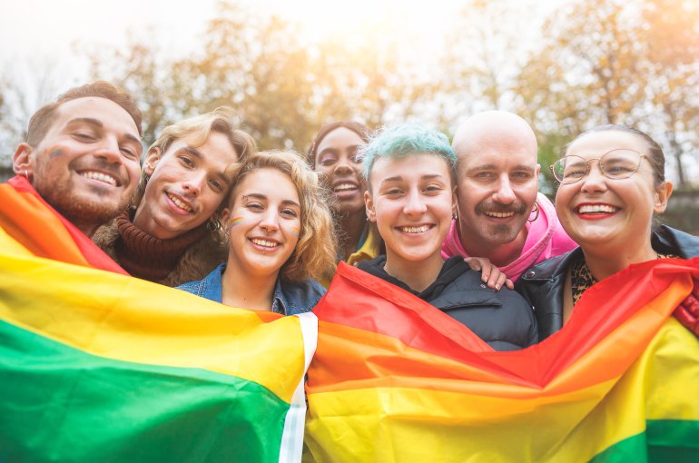 Een groep jongeren die actievoert voor LHBTQI+ rechten met een regenboogvlag