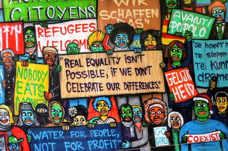 Foto van muurschildering met activistische borden over quality
