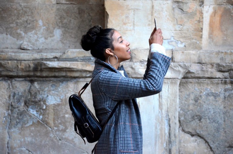 Jonge vrouw filmt zichzelf met smarthphone