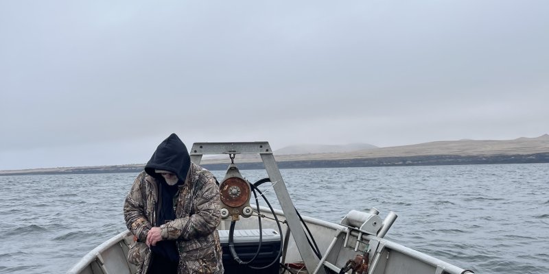 Hooded fisherman on a boat