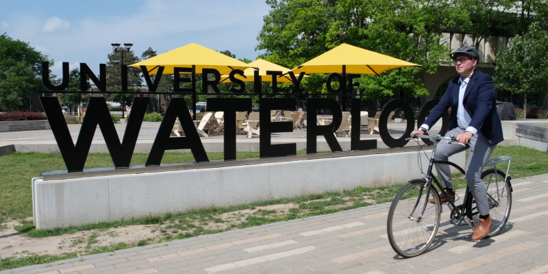 Brian Doucet fietst op de campus van Universiteit Waterloo, Canada