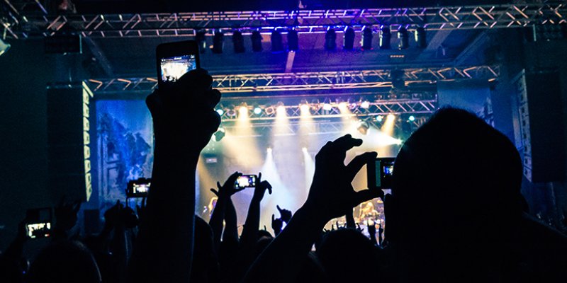 Silhouette of hands holding a mobile phone and taking a video of a rock concert © iStockphoto.com/jericho667